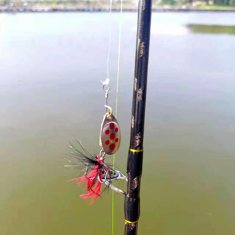 Fishing rod with red and silver lure by a calm outdoor lake