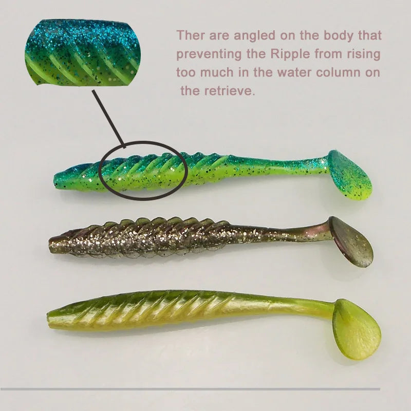 Three soft plastic fishing lures with ribbed bodies and paddle tails on a white background.