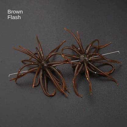 Pair of brown flash silicone fishing lures with multi-leg design on black background.