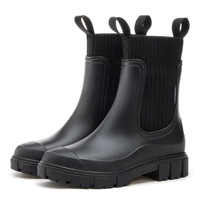 Pair of black rubber boots with elastic sides on a white background