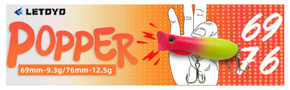 Colorful popper fishing lure with treble hooks, shown in front of vibrant orange graphic background.