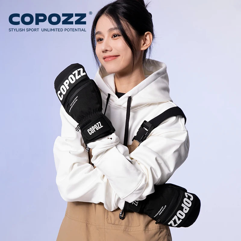 Person wearing black COPOZZ gloves and a white jacket with a light blue background