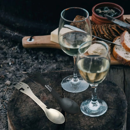 HookUpCo 5-in-1 black and silver survival tool with multi-tipped fork, spoon, and can opener on rustic wood.