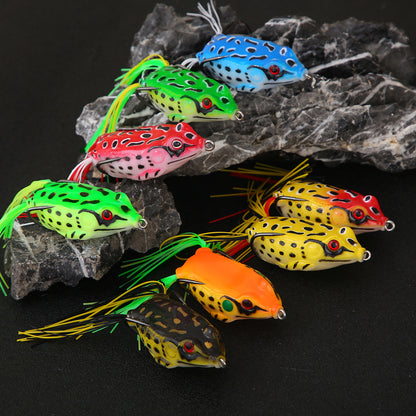 Colorful frog fishing lures with lifelike designs displayed on black rocks