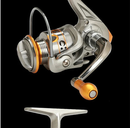 Close-up of a silver and orange spinning fishing reel on black background, outdoor gear