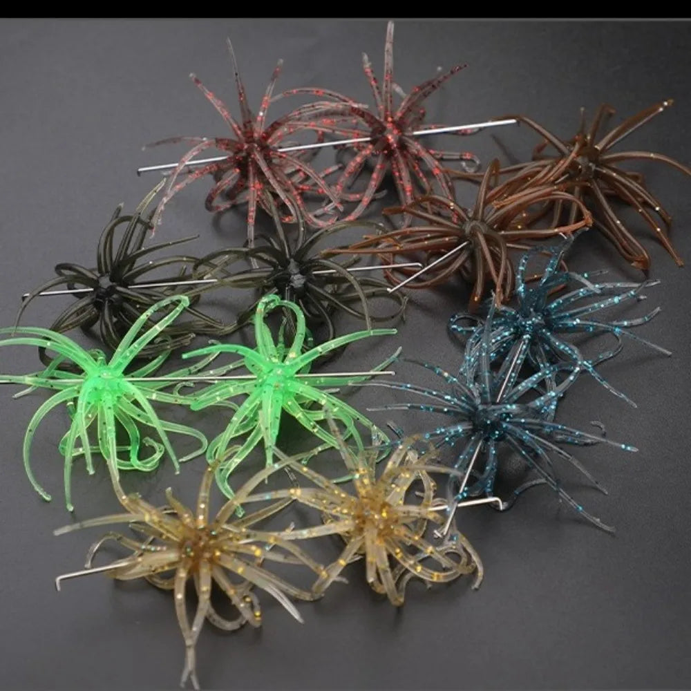 Assorted colorful soft plastic spider fishing lures with hooks on a dark background.