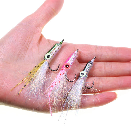 Hand holding three colorful squid-shaped fishing lures with sparkling tails, outdoor gear