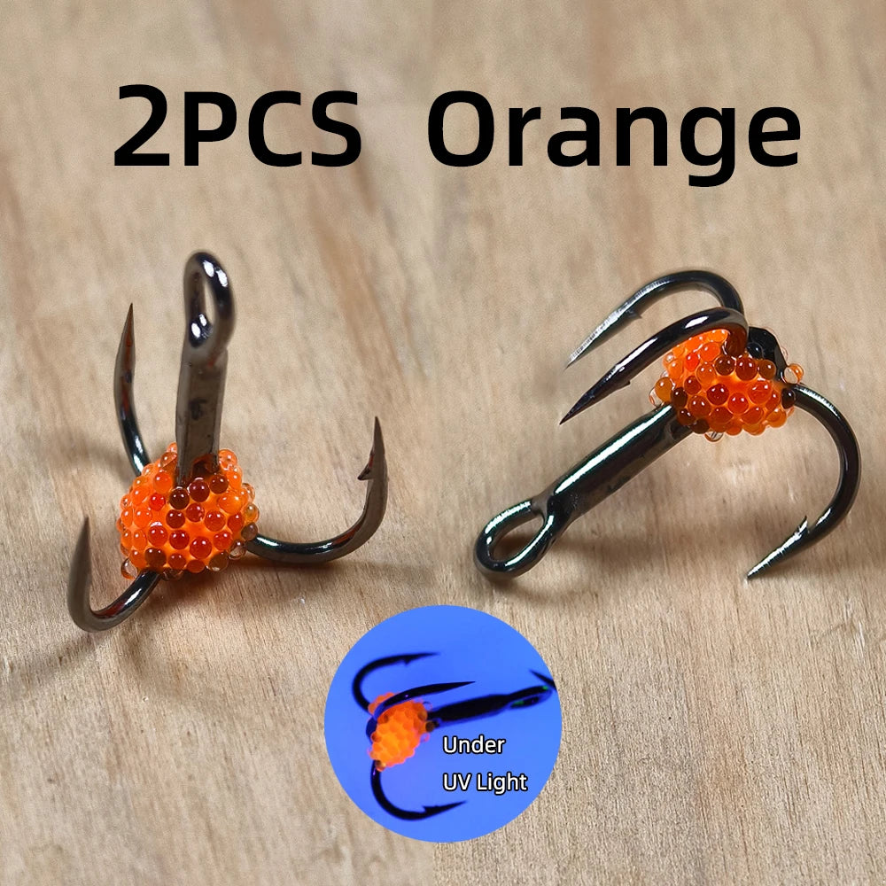 2PCS orange fishing treble hooks with orange bead bait, UV reactive, on wooden surface.