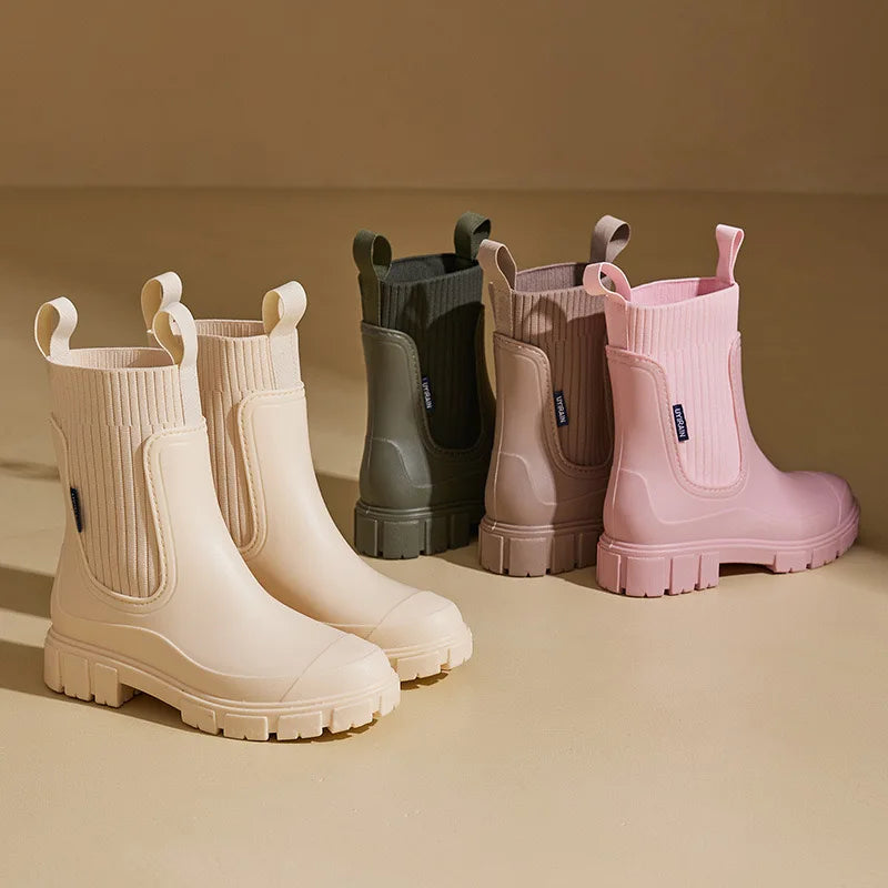 Set of colorful rain boots on a beige background