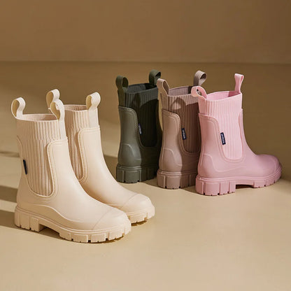 Set of colorful rain boots on a beige background