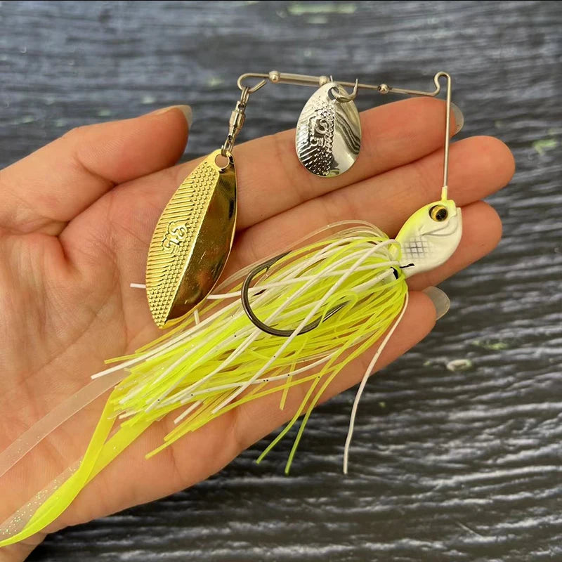 Hand holding yellow and white spinnerbait fishing lure with metal blades for outdoor fishing.