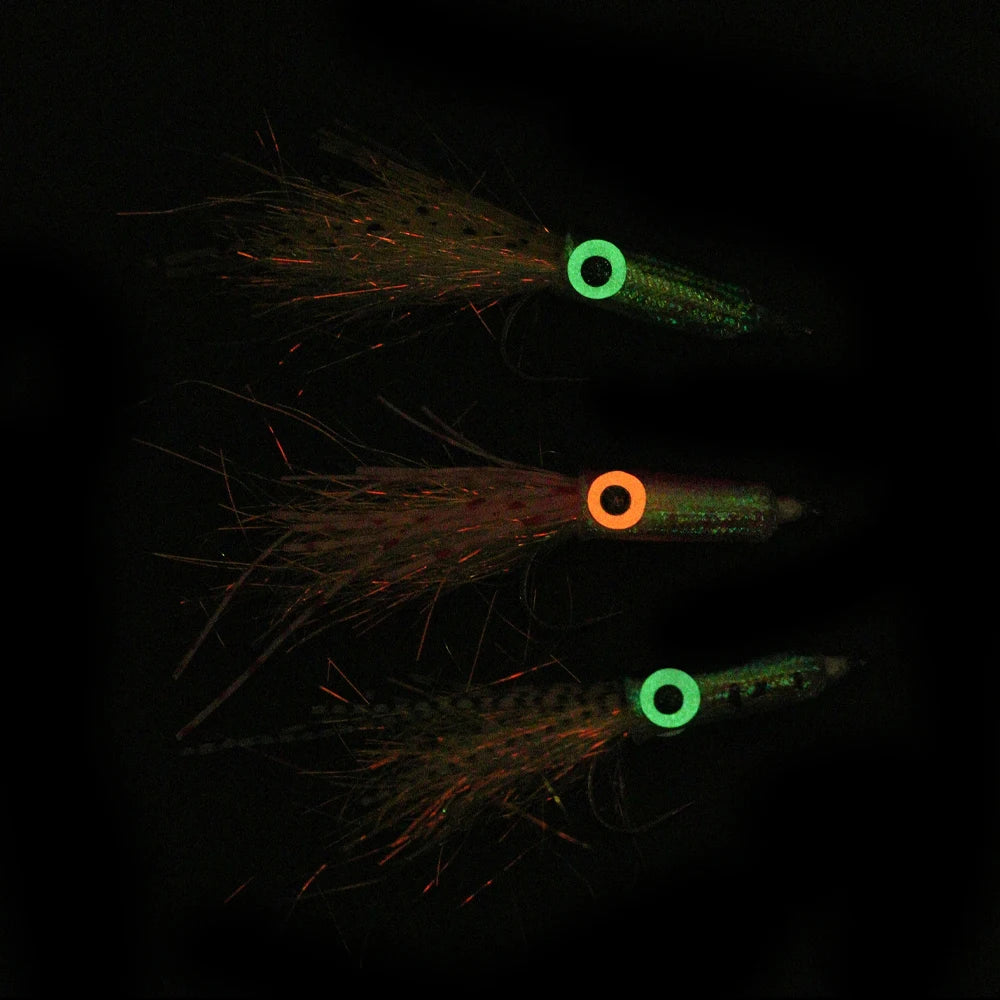 Glow in the dark fishing lures with colorful eyes and feathered tails, outdoor gear
