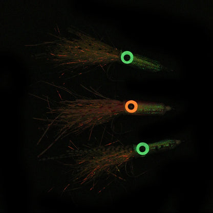 Glow in the dark fishing lures with colorful eyes and feathered tails, outdoor gear