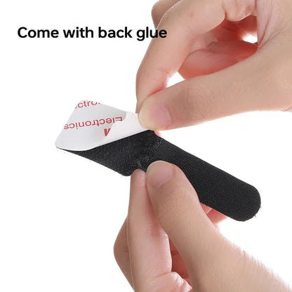 Hand applying black self-adhesive cable straps with backing glue for tidy wire organization.