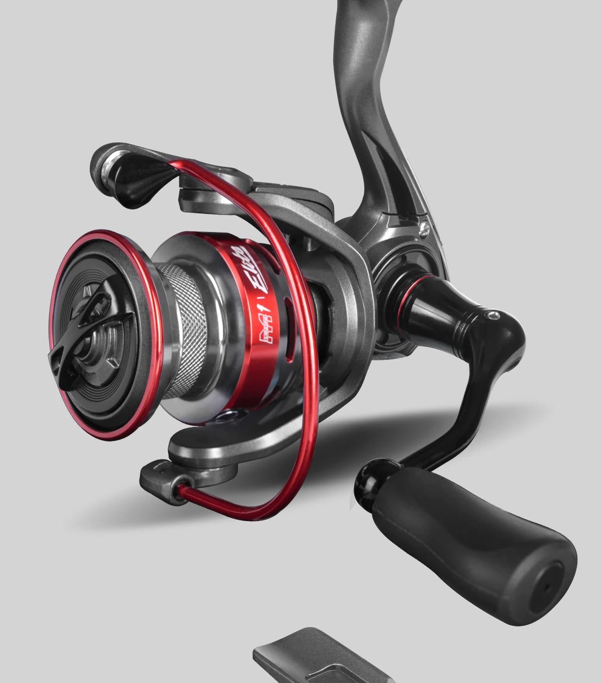 Modern spinning fishing reel with red and black accents on gray background