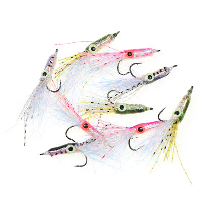 Assorted colorful fishing lures with hooks and shimmering tails on white background