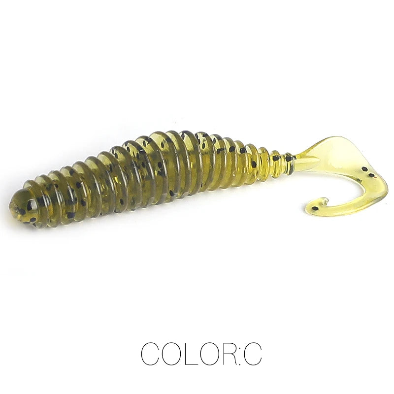 Soft plastic ribbed fishing lure with curly tail in translucent olive color with black specks